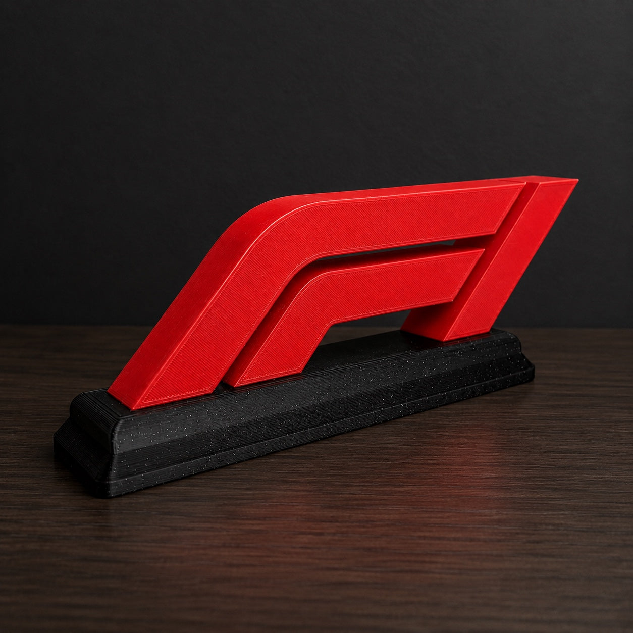 Titan Racing Emblem — red motorsport-inspired emblem on matte-black desk stand